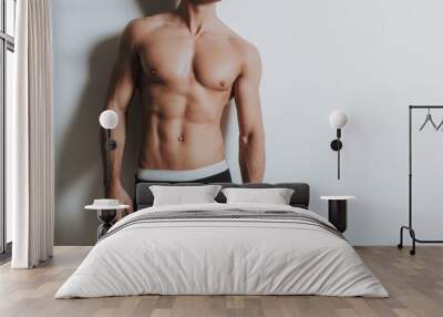 Young shirtless athletic man standing in black underwear Wall mural