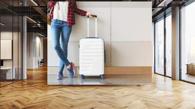 Young woman wearing casual clothes is posing at airport Wall mural