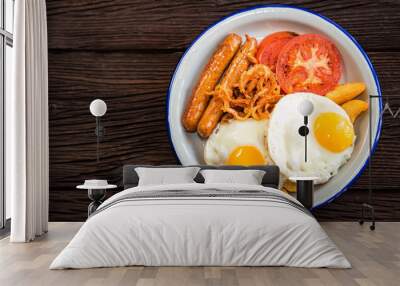 Typial breakfast with eggs, tomato, onion rings and sausage on plate Wall mural