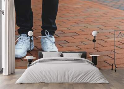 lower part of the male legs in white sneakers Wall mural