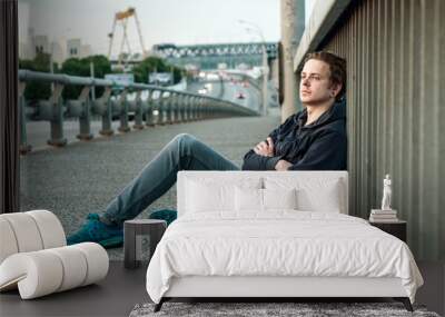 young man is sitting near fencing Wall mural