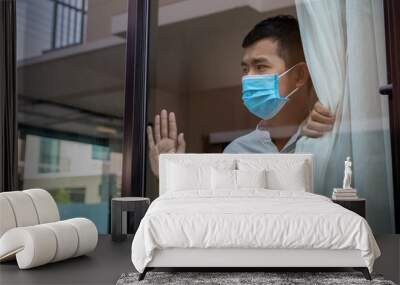 Man in medical mask stay at home. Man in medical mask stay for quarantine time at home, Coronovirus pandemic. Wall mural