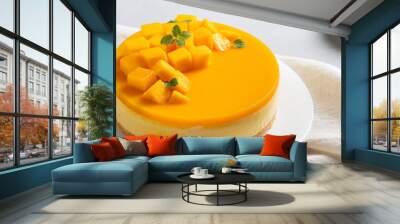 Delicious glazed mango no baked cheese cake with fresh diced mango pulp topping on bright table background. Wall mural