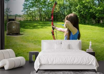 A young girl is practicing archery Wall mural