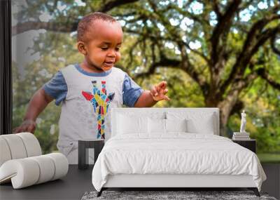 An African American toddler is playing outside on a sunny day Wall mural