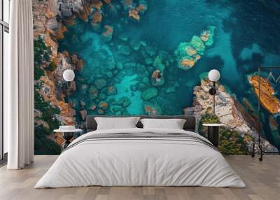 A beautiful blue ocean with rocks and a cliff in the background Wall mural