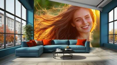 A young woman with long silky hair smiles brightly as she enjoys a summer evening outdoors, surrounded by nature and warm sunlight Wall mural