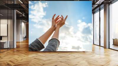 Human hands open palm up on sky background. Wall mural