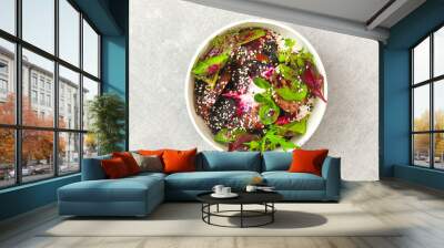 Salad of lettuce, beet and chicken liver with fresh radicchio and sesame seeds in a takeaway round container topped with yoghurt sauce on gray background. Healthy food delivery concept. Wall mural