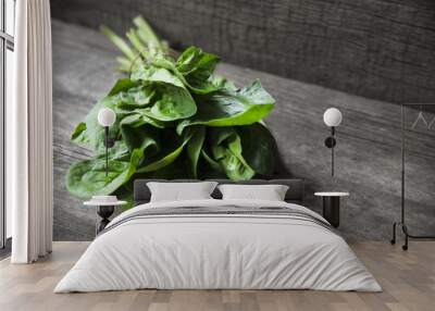 Bunch of fresh spinach wrapped with twine on old wooden surface. Dark rustic style Wall mural