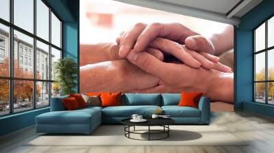 Worried caucasian man gently stroking hand of his sick old mother showing care or love. Son comforting wrinkled arm of elderly mom sitting at bed. Guy giving support to his old parent slow motion. Wall mural