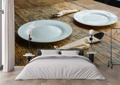 two empty white dishes with cutlery on the old wooden table. food and tableware concept. Wall mural