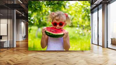 A child eats a watermelon in the park. Selective focus. Wall mural