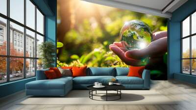 glass ball in hands on a background of nature. Selective focus. Wall mural