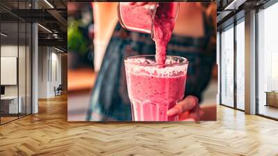 woman making berry smoothie in the kitchen. selective focus. Wall mural