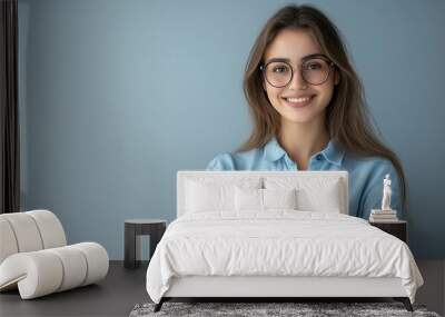 Happy young smiling confident professional business woman wearing blue shirt and glasses, happy pretty female executive looking at camera, standing arms crossed isolated at gray background Wall mural