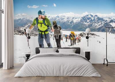 A group of mountaineers climbs to the top of a snow-capped mountain Wall mural