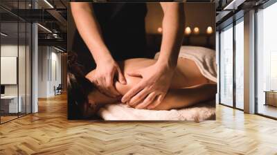 Close up Male manual worker doing spa massage to a young girl in a dark room Wall mural