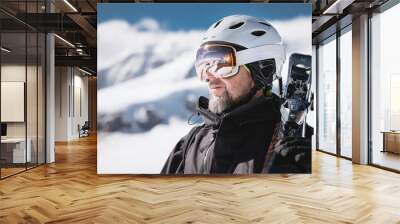 Close-up Portrait bearded male skier aged against background of snow-capped Caucasus mountains. Ski resort concept Wall mural