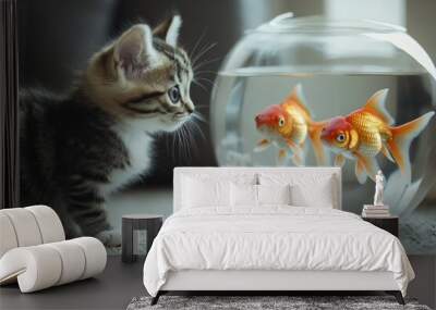 Curious Feline Observation: A Kitten Intently Watches Two Goldfish Swimming in a Glass Bowl, Capturing Innocent Curiosity and Fascination Between Species. Wall mural