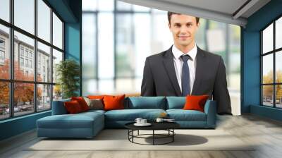 Portrait of a confident young businessman standing in an office and looking at camera Wall mural