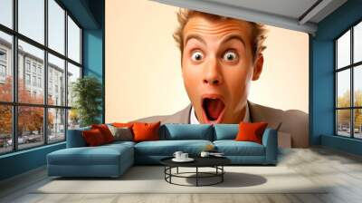 Surprised young businessman with open mouth on beige background. Wall mural