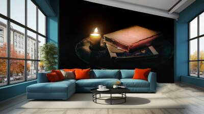 Vintage still life with lighting frame candle and old book in dark background Wall mural