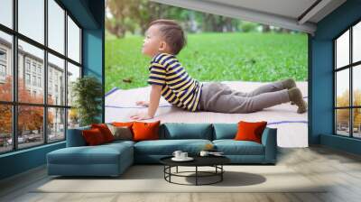 cute little asian 30 months / 2 year old toddler baby boy child practices yoga in cobra pose and med Wall mural