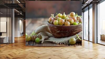 Ripe gooseberries fruit in bowl with sackcloth on wood table 
 Wall mural