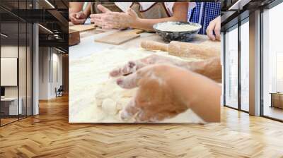 The cook teaches children to making dough. The female hand kneads the dough on a floured table. Master class in baking. Cooking at home. Wall mural