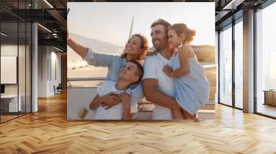 Happy tourists, beautiful family taking selfie while standing together outdoors ready for boarding the plane at sunset. Vacation, parenthood, traveling concept Wall mural