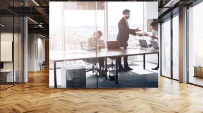 People standing near table, team of young businessmen working together in office. Blurred background Wall mural