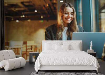 Stylish woman manager freelancer working on laptop while sitting in cozy cafe. High quality photo Wall mural