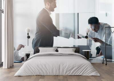 Team of young businessmen working and communicating together in office. Blurred background Wall mural