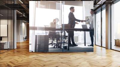 Team of young businessmen working and communicating together in office. Blurred background Wall mural