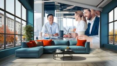 Workteam of young asian businessman working and communicating together in an modern office.  Wall mural