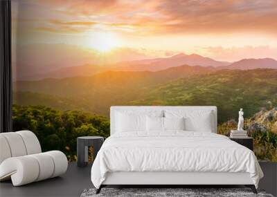 highland mountain landscape of beautiful sunset or sunrise with nice mountain peaks and slopes, green and golden hills and majestic cloudy sky on background Wall mural