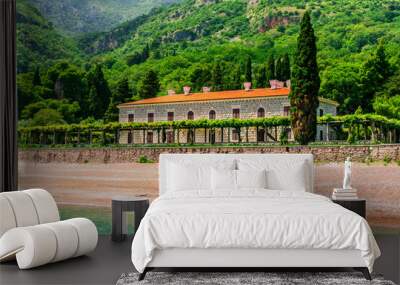 panoramic view from adriatic sea bay to a beach and beautiful palace of Oman hotel in Budva, Montenegro with green garden and mountains Wall mural