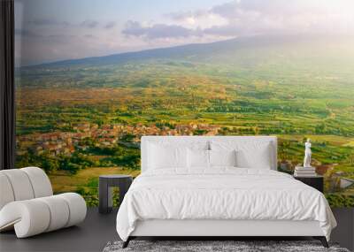 scenic rustic landscape with green hills and farms in a mountain valley during colorful cloudy sunset Wall mural