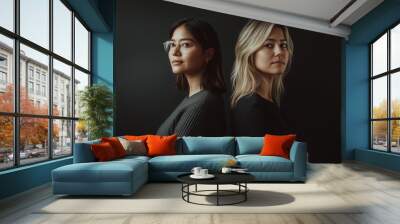 Two women standing back-to-back , clean dark backdrop Wall mural