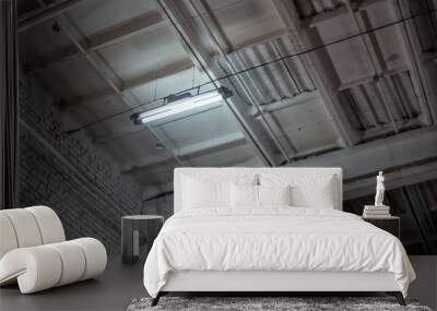 the ceiling of an industrial building with lighting in one lamp, photo from bottom to top Wall mural