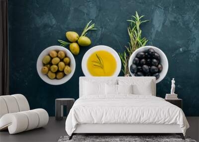 A set of olives and olive oil and rosemary. Green olives and black olives. On a black stone background. Free space for text. Wall mural