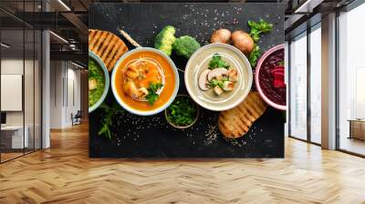 assortment of colored vegetable cream soups. dietary food. on a black stone background. top view. fr Wall mural