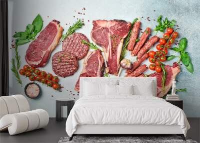 Assortment of meat and meat products. Steak, ribeye steak, kebab and burger patty. On a gray stone background. Top view. Wall mural