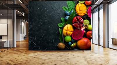 Background of exotic fruits. Ripe tropical fruits on a stone background. Copy space. Top view. Wall mural