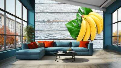 Banana with green leaves on a white wooden table. Tropical Fruits. Top view. Free copy space. Wall mural