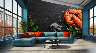 Boiled lobster with vegetables on a black stone plate. Seafood. Top view. Free space for your text. Wall mural