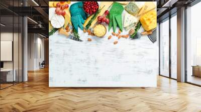 Cheese on a wooden board: brie, blue cheese, parmesan and maasdam. On a white wooden background. Free copy space. Top view. Wall mural