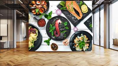 Dishes of seafood. Seafood on a plate. On a white wooden background. Top view. Free copy space. Wall mural