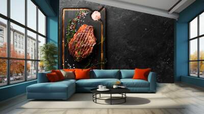 Dry aged Grilled ribeye beef steak with ingredients on a black stone background. Top view, free copy space. Wall mural